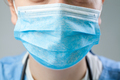 Caucasian doctor or nurse wearing blue protective surgical face mask - PhotoDune Item for Sale