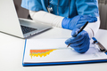 Doctor wearing protective gloves analyzing COVID-19 info data - PhotoDune Item for Sale