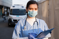 Young female NHS UK EMS doctor in front of healthcare ICU facility - PhotoDune Item for Sale