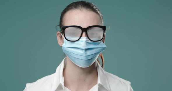 Woman wearing a surgical mask and fogged up glasses