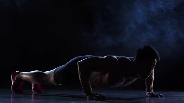 Asian Athlete Push Ups, Squeezes From the Floor, He Is Strong and Hardy, Black Background Slow