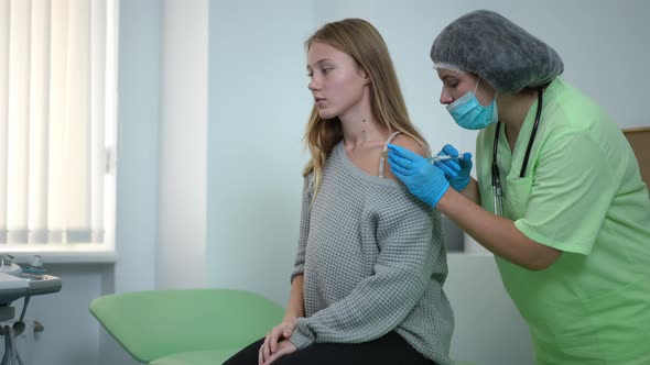 Side View Pregnant Woman Getting Covid19 Vaccine Shot in Hospital Indoors