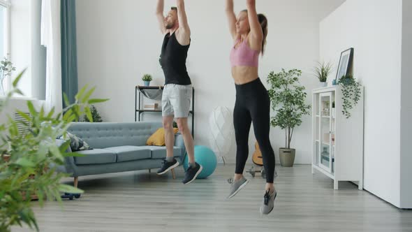 Man and Woman Doing High Intensity Interval Training Exercising Together at Home