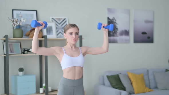 Athletic Young Woman Working Out with Dumbbells at Home