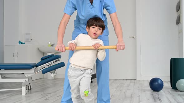 Physiotherapist and Kid Walking in Rehabilitation Center