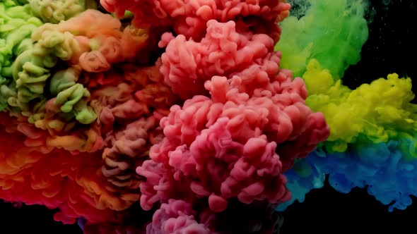 Colorful Rainbow Paint Drops From Above Mixing in Water. Ink Swirling Underwater.