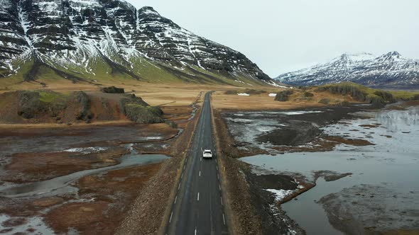 Beautiful Road on a Volcanic Landscape in Iceland. Drone Flying Behind the Car