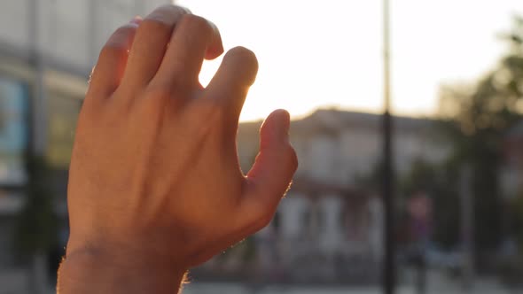 Unrecognizable Young Adult Man Guy Stretches Out Male Hand in Sun in City Faith in God Dream