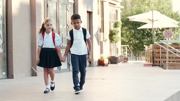 Children with Backpacks Come Back From School and Smiling.