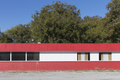 Empty red and white roadside building with boarded up windows. - PhotoDune Item for Sale