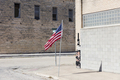 American flag flying outside a building on a main street. - PhotoDune Item for Sale