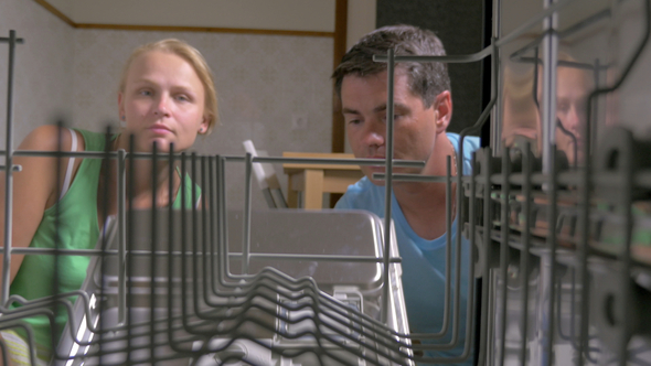 Family Couple Putting Plates Into the Dishwasher