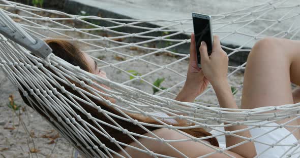 Summer Vacation of happy Asian woman wearing white bikini using mobile phone