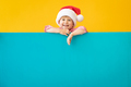 Happy child holding blue Christmas banner blank against yellow background - PhotoDune Item for Sale