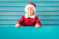 Happy child holding blue Christmas banner blank against wooden background - PhotoDune Item for Sale