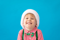 Happy child dressed Santa Claus hat against blue background - PhotoDune Item for Sale