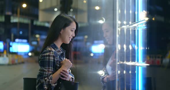 Woman go window shopping at night