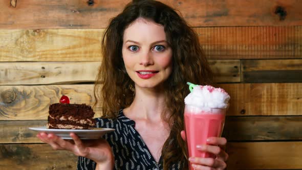 Portrait of female customer holding plate with pastry and icecream float