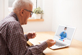 Elderly caucasian retired man talking to young UK female doctor via online video call - PhotoDune Item for Sale