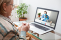 Young female doctor consulting with elderly woman over video help line virtual medical appointment - PhotoDune Item for Sale