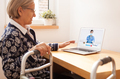 Retired senior elderly woman with mobility problem talking to UK NHS GP female doctor via video call - PhotoDune Item for Sale