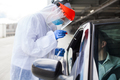 Medical worker in PPE performing nasal & throat swab on person in vehicle through car window - PhotoDune Item for Sale