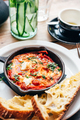 Shakshuka in iron pan served with bread - PhotoDune Item for Sale