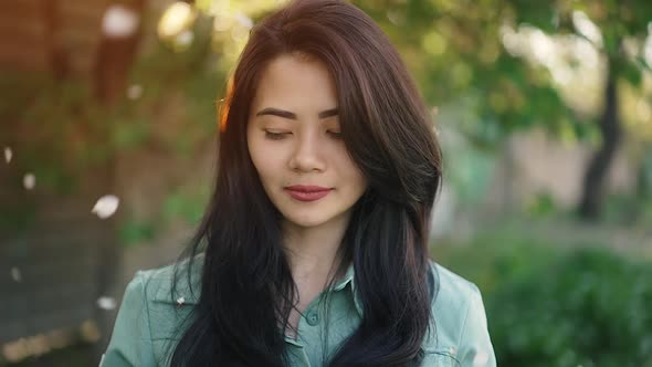 Petals From the Tree Fall on the Asian Girl