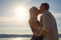 Romantic couple kissing on beach against the sun - PhotoDune Item for Sale