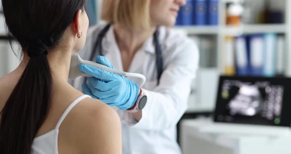 Doctor's Hands with a Probe on a Woman's Neck