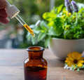 Essential oil drop fall in a bottle, close up. Alternative health medicine. Fresh herb in a mortar - PhotoDune Item for Sale