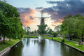 Windmill De Valk at sunset, tower mill and museum in Leiden city, Holland Netherlands. - PhotoDune Item for Sale