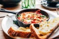 Shakshuka in iron pan served with bread - PhotoDune Item for Sale