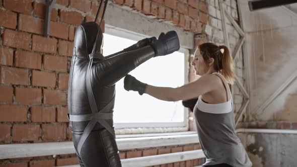 Female Boxer Striking Punching Bag