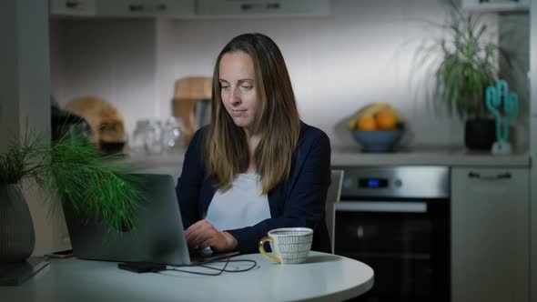 Woman freelancer typing on a laptop looking at the computer screen working at home