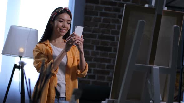 Young Female Painter Taking Photo of Her Artwork