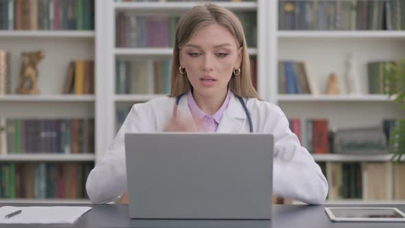 Lady Doctor Talking on Video Call on Laptop in Clinic alt