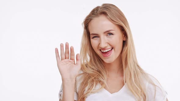 Young Beautiful Caucasian Blonde Girl Suprisingly Smiling on White Background in Slowmotion