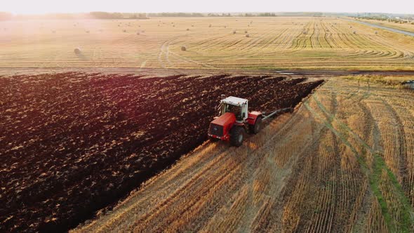 Aerial View of a Agricultural Tractor with a Plow During Field Work on One Agricultural Field in