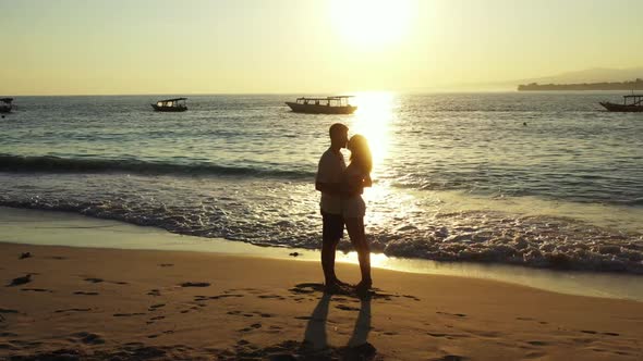 Romantic couple sunbathe on exotic resort beach time by clear ocean and white sand background of Lom