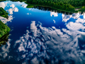 Aerial view of boat in blue water lake with clouds and sky reflection and green forest in Finland - PhotoDune Item for Sale