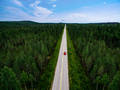 Aerial view of red car wdriving the route through green summer woods in Finland. - PhotoDune Item for Sale