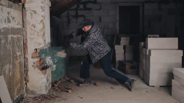 Man Breaks Brick Wall with Sledgehammer