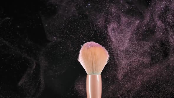 Two Makeup Brushes with Pink Powder Blush on a Black Background