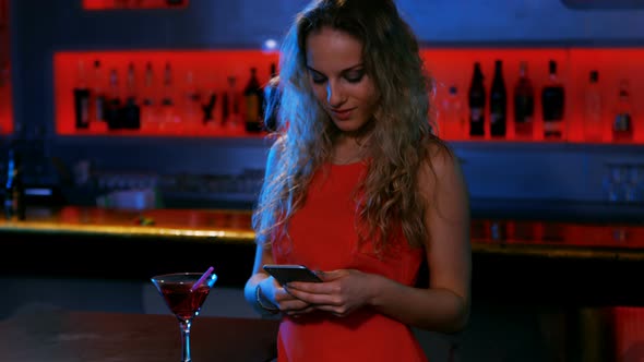 Stylish woman text messaging in the bar