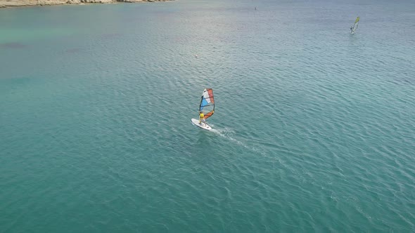 Aerial view of man doing windsurfing at the sea in Greece.