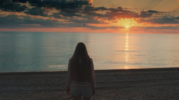 Medium Shot of Woman Walking To the Sea and Raising Her Hands Up