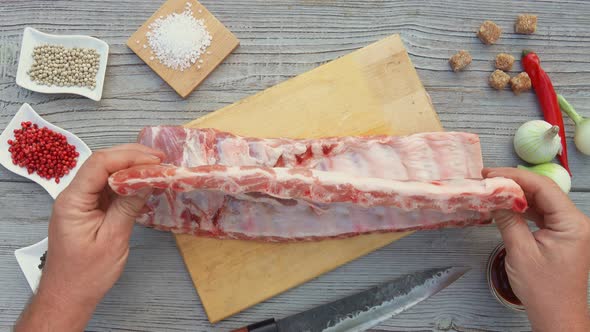 Top View of the Male Hands Preparing Raw Ribs for the Grill