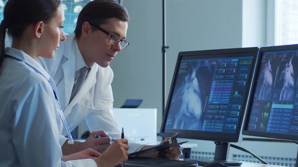 Professional medical doctors working in hospital office making computer research.