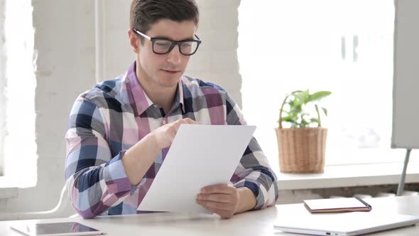 Young Man Reading Documents